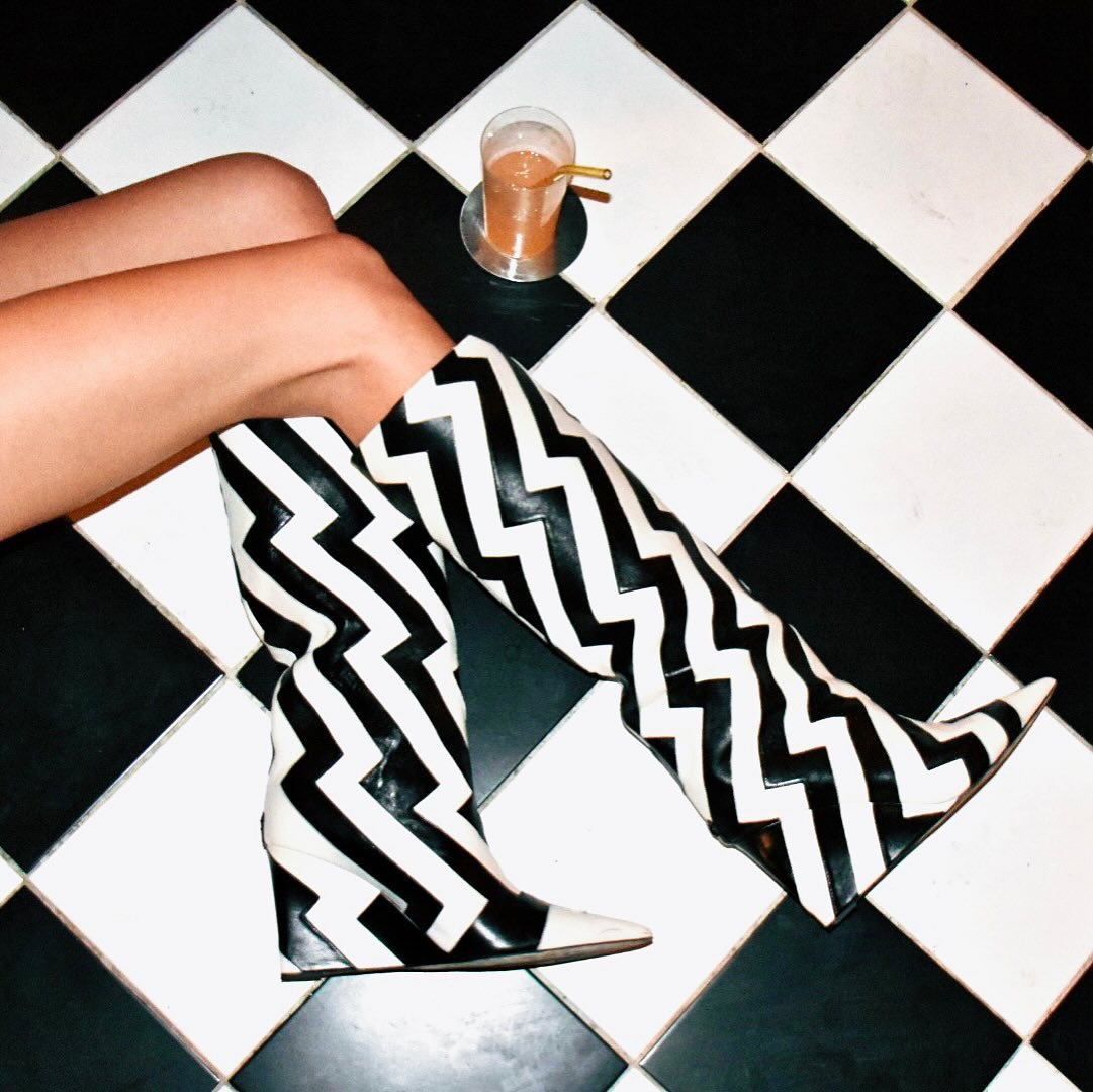 Bottes graphiques noir et blanc sur le sol en damier de LPDO