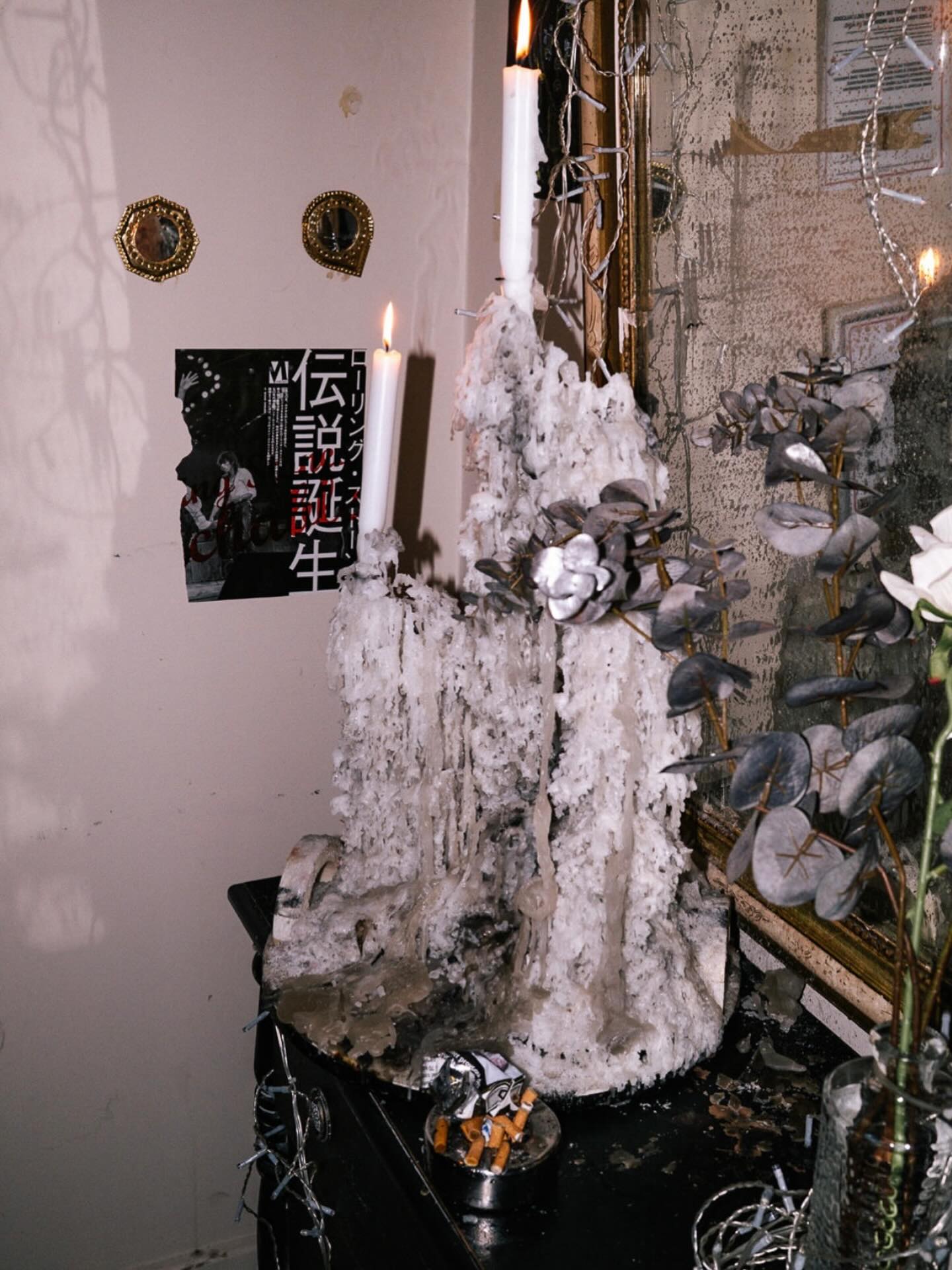 Bougies fondues, miroirs dorés et affiche japonaise dans un coin de LPDO